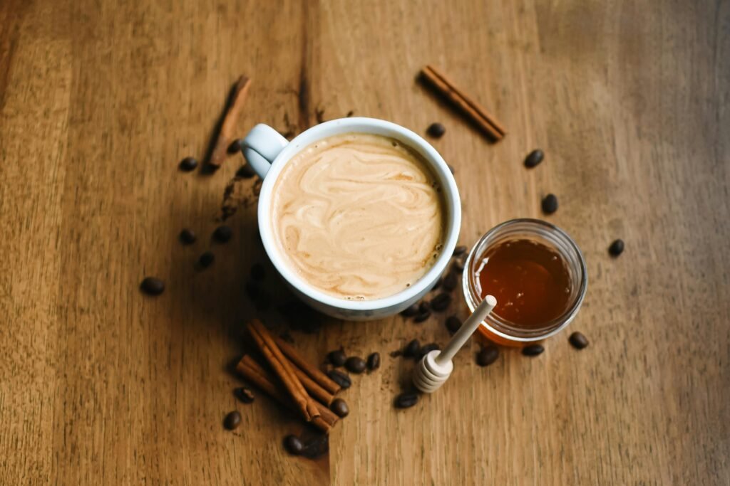 A warm cappuccino in a ceramic cup with Moroccan Spiced Coffee (Gahwa)honey and cinnamon, perfect for cozy mornings.