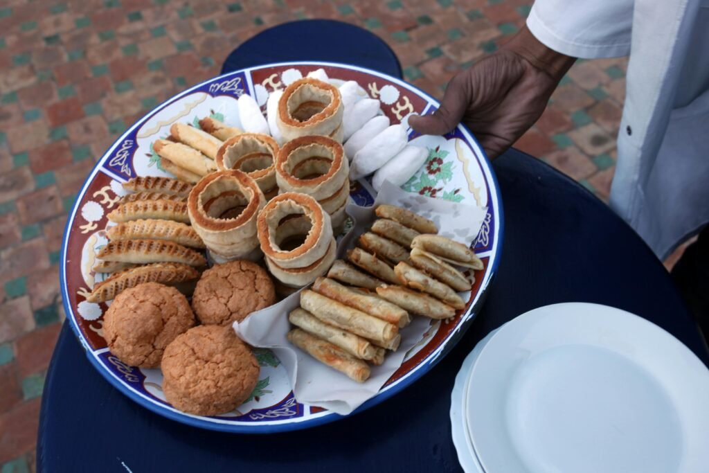 A platter of traditional Moroccan pastries on a decorative plate highlights Moroccan culinary artistry.
